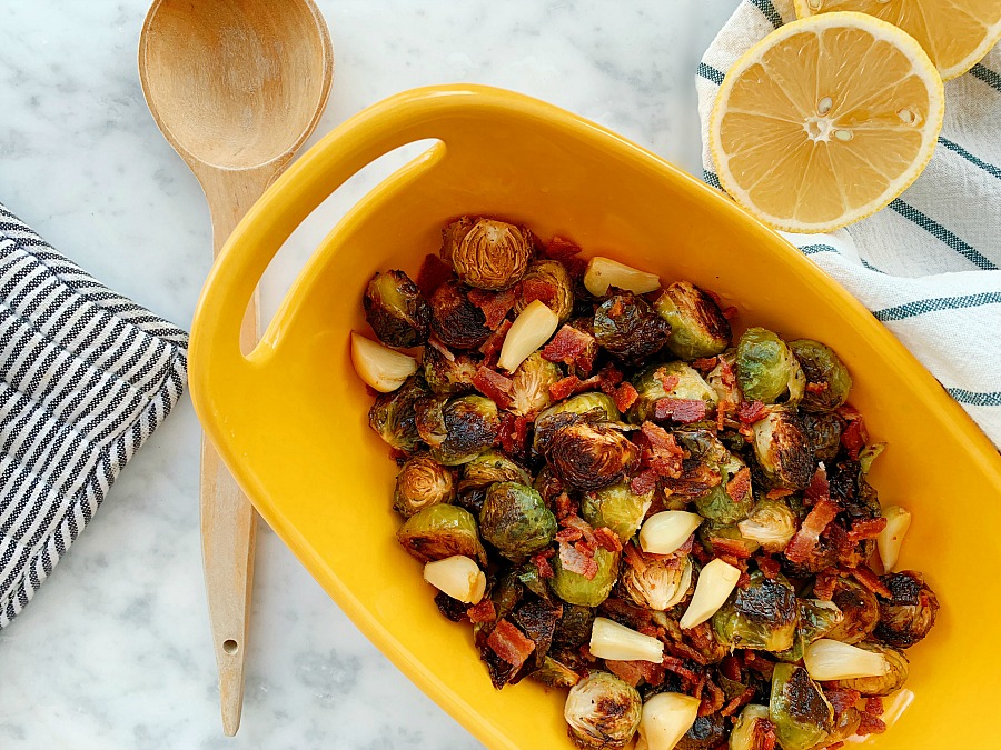 This sheet pan side dish is packed with flavor! A super easy and quick side dish for any meal! Roasted Brussels sprouts, crispy bacon and creamy roast garlic. And it's paleo! 